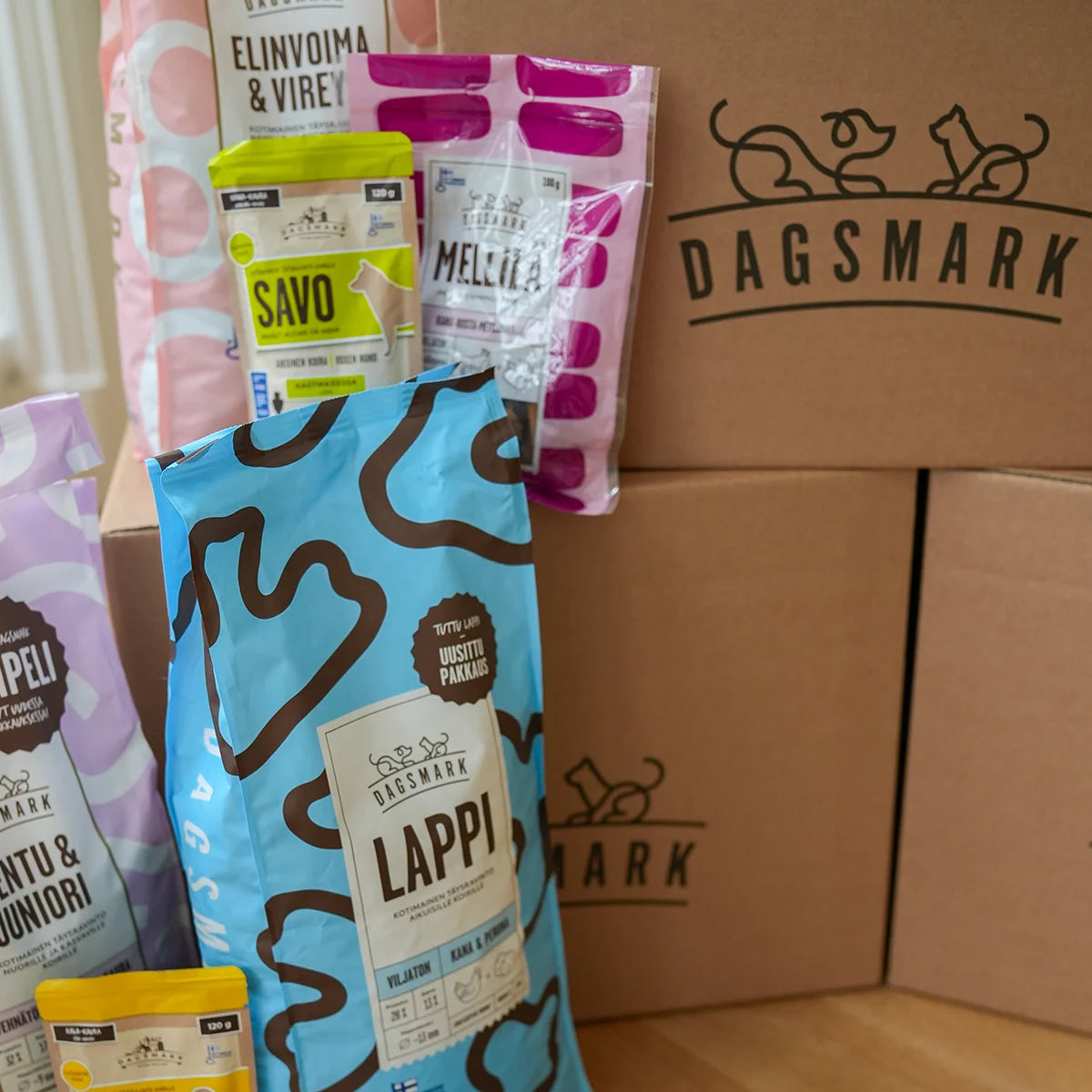 Dagsmarkin koiranruokapakkauksia ja verkkokaupan omia kuljetuslaatikoita